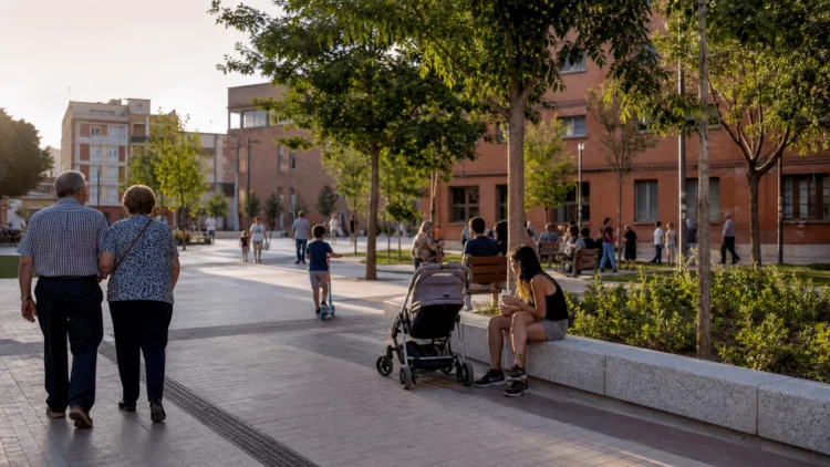 Vecinos pasean y descansan en un espacio público renovado de un barrio de Madrid